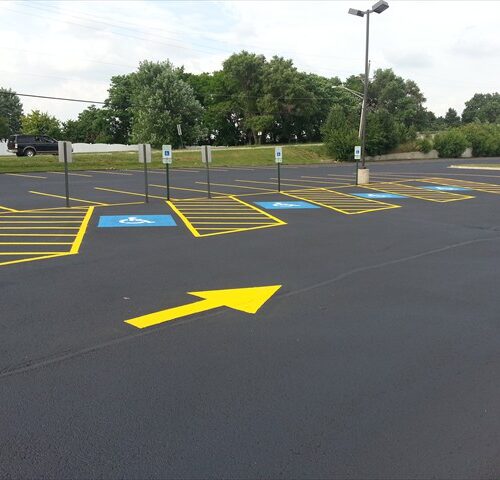 A parking lot with yellow arrows painted on it.