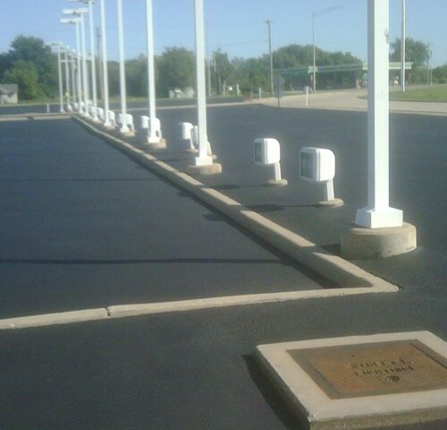 A parking lot with many white poles and a brown plaque.